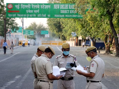 Police personnel wearing protective masks check paperwork for migrant workers being bused in by Delhi Transport Corporation (DTC) from their respective Covid-19 quarantine camps to New Delhi Railway Station in New Delhi, India, on Thursday, May 7, 2020. The federal government announced it would start running special trains to transport stranded migrant workers. Local authorities will screen the passengers and only those found to be symptom-free would be allowed to travel, the home ministry said. Photographer: T. Narayan/Bloomberg