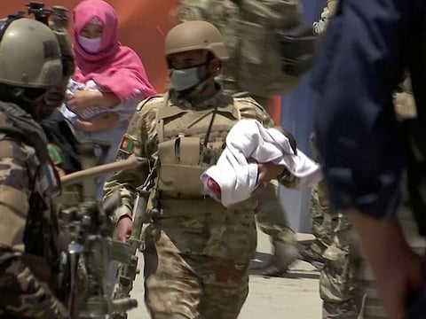 Afghan security personnel evacuate a baby from a hospital, where the international humanitarian organisation Doctors Without Borders runs a maternity clinic, that was attacked in Kabul, Afghanistan May 12, 2020.
