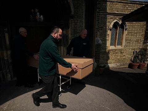 Mortuary workers push a coffin containing the body of a deceased person from the mortuary to a hearse at Poppy's Funerals in Lambeth Cemetery, as the spread of the coronavirus disease (COVID-19) continues in London, Britain, May 4, 2020. 