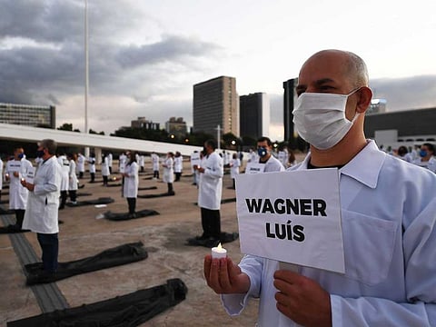 Brazilian nurses honour health workers who have died of the novel coronavirus COVID-19, during a demonstration in Brasilia, on May 12, 2020. The new coronavirus was circulating in Brazil in early February, weeks earlier than initially detected, and just before millions of people were partying in the streets for carnival, according to a new study. 