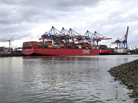 Wind turbines stand beyond the HHLA Container Terminal Altenwerder GmbH(CTA) One Stork at the Port of Hamburg on the River Elbe in Hamburg, Germany, on Wednesday, May 13, 2020. German factories saw demand collapse in March, when measures to contain the coronavirus brought the economy to a sudden halt. 