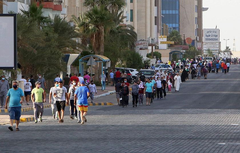 Residents walk in a neighbourhood of Kuwait City. Employers must secure prior approval from relevant authorities before providing housing for workers.