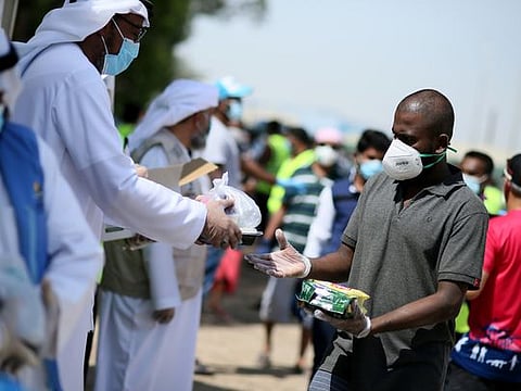 Dr. Hisham Al Zahrani, Deputy Director of Dar Al Ber Society, and Sakhr Al Khalili, Manager-Staff Accommodation, Assets & Property Management - JAFZA, along with Dar Al Ber Society staff distribute 12,000 food meals  and 40,000 Tea Lattes to blue collar workers at their camp in Jebel Ali on 14th May
