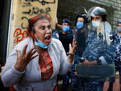 An anti-government protester yells at riot police in front of the Ministry of Economy in downtown Beirut, Lebanon, on May 11, 2020.
