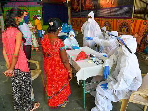 Doctors and medical staff attend residents at a COVID-19 coronavirus community clinic during a nationwide lockdown imposed as a preventive measure against the COVID-19 coronavirus, in Mumbai on May 19, 2020. 