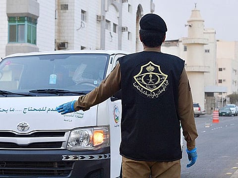 A Saudi security man enforces a curfew in the holy city of Medina. 