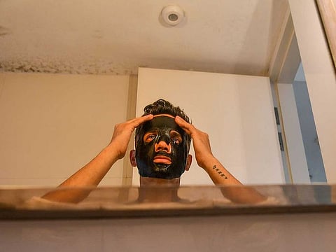 29-year-old television anchor Lakshay Narula putting on a face mask at his home in Mumbai, India.
