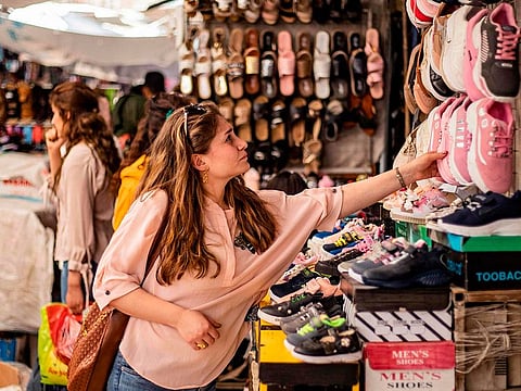 A woman inspects a shoe at the main market of the Kurdish-majority city of Qamishli in Syria's northeastern Hasakeh province on May 19, 2020, ahead of the upcoming Muslim holiday of Eid al-Fitr celebrated at the conclusion of the holy fasting month of Ramadan.