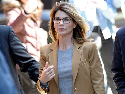 (FILES) In this file photo taken on April 03, 2019, actress Lori Loughlin arrives to face charges for allegedly conspiring to commit mail fraud and other charges in the college admissions scandal at the John Joseph Moakley US Courthouse in Boston.   Loughlin has agreed to plead guilty to conspiracy charges linked to the sprawling college admissions scandal, US prosecutors said on May 21, 2020. The terms of the plea agreement will see the star of the 1980s-90s sitcom "Full House" serve two months in prison, with a $150,000 fine and two years of supervised release with 100 hours of community service. She and her husband were among 50 people indicted in the elaborate scam to help children of the elite secure spots at top US colleges. / AFP / Joseph Prezioso