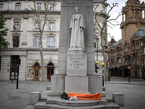 A homeless person sleeps on the plinth of the Edith Cavell Memorial near Charing Cross station in London on May 22, 2020 as lockdown restrictions to combat the spread of the novel coronavirus remain in place. 