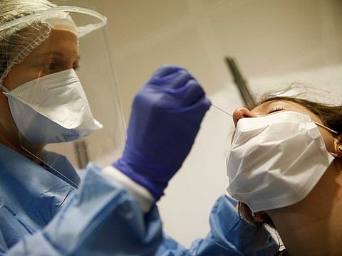 A health-care worker collects a swab sample to be tested for coronavirus at the European Parliament in Strasbourg, eastern France, on May 12, 2020. 