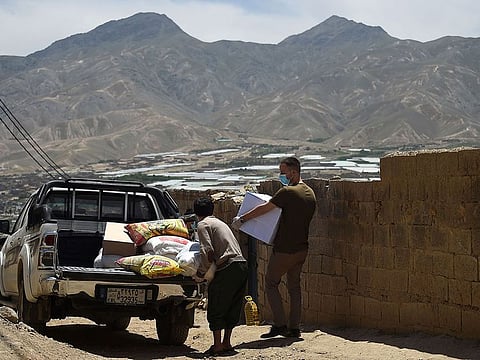 Volunteers carry relief aid on the outskirts of Kabul.