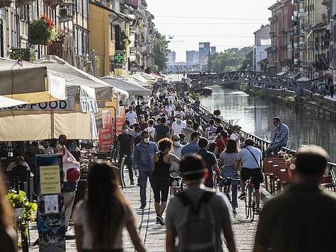People relax at the Naviglio Grande canal, in Milan, Italy.