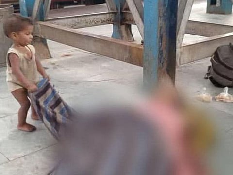 The toddler playing with the shroud of his dead mother at Muzaffarpur station in Bihar.