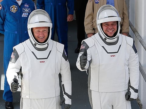 NASA astronauts Douglas Hurley, left, and Robert Behnken walk out of the Neil A. Armstrong Operations and Checkout Building on their way to Pad 39-A, at the Kennedy Space Center in Cape Canaveral, Florida, on Saturday, May 30, 2020. 