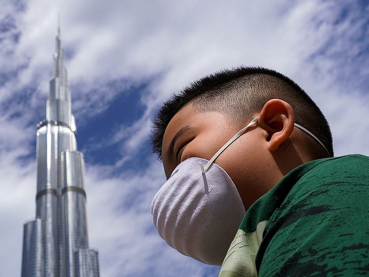 boy wearing mask, burj khalifa, covid-19 in uae