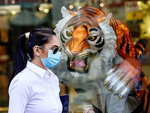 A resident wearing mask walks past a showroom in Bur Dubai. 