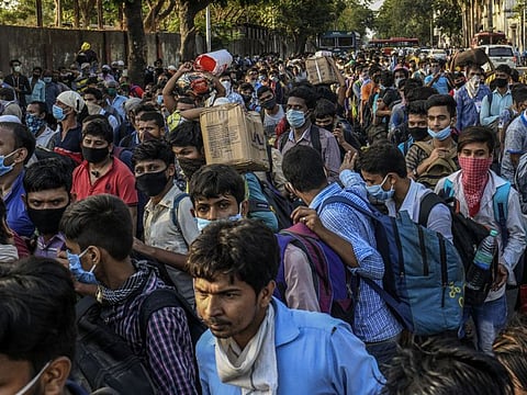 Migrant workers from Bihar crowd outside a train station in Mumbai. While many of the migrants returned to heir native towns and villages in Bihar since the start of the lockdown, some have started going back to their places of work in search of jobs. 