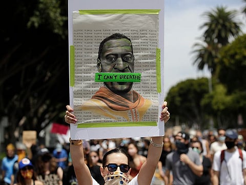 A protester holds a sign with an image of George Floyd Tuesday, June 2, 2020, in the Venice area of Los Angeles during demonstrations over the death of Floyd, who died in police custody in Minneapolis on May 25. 