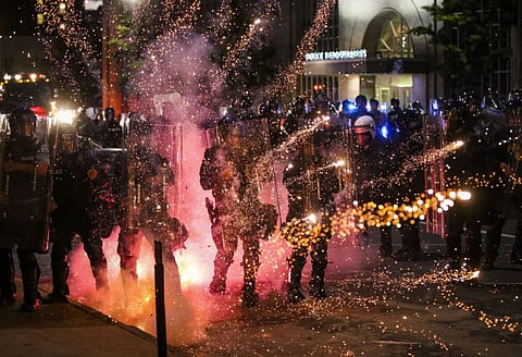 Fireworks explode in front of police as they clash with protesters in front of the St Louis Police Headquarters in Downtown St Louis.