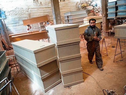 A worker walks next to coffins made of Mapresa (pressed wood) at a factory at Juan de Lurigancho district in Lima, on June 4, 2020 amid the COVID-19 coronavirus pandemic