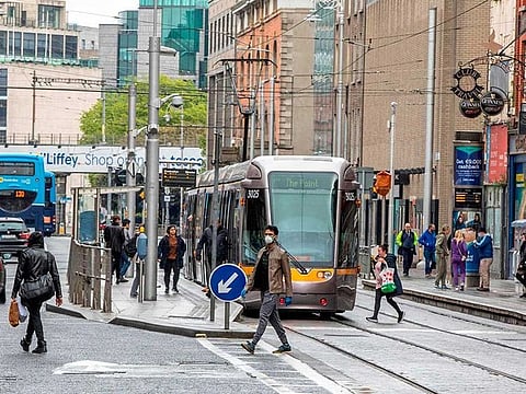 People cross the tram tracks in Dublin City centre in Ireland, as Ireland cautiously begins to lift it's coronavirus lockdown.