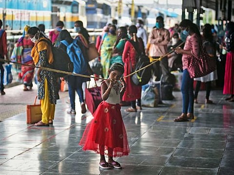 A girl leans on a rope as she waits with other passengers to board Golconda Express at Vijayawada Railway Station in Andhra Pradesh as India Railways announces partial resumption of train services, during Unlock 1.0, in Vijayawada on Monday. Authorities in the state have started a probe into how 116 people in a single village have been infected with the coronavirus.