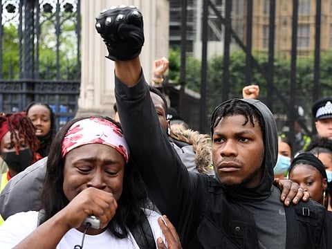 Protestors including British actor John Boyega (C) raise their fists in Parliament square during an anti-racism demonstration in London, on June 3, after George Floyd, an unarmed black man died after a police officer knelt on his neck during an arrest in Minneapolis, US.