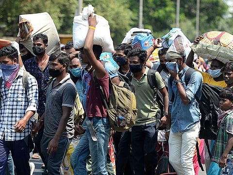 Stranded migrant labourers walk to an assembling centre to get transferred to a railway station to board a special train to Bihar after the government eased a nationwide lockdown imposed as a preventive measure against the COVID-19 coronavirus, in Chennai on May 30, 2020. 