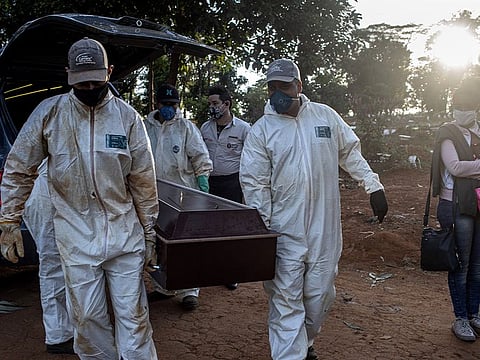 Grave diggers carry the coffin of a coronavirus victim before burial at the Vila Formosa cemetery in São Paulo, Brazil, May 28, 2020