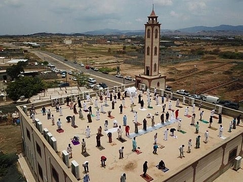 Worshippers perform the Friday prayers on a mosque roof in Saudi Arabia.