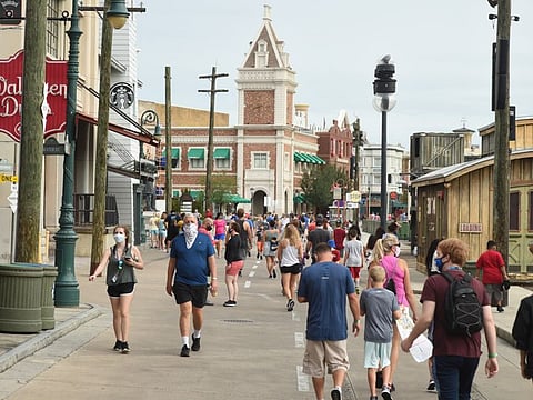 Park guests wearing protective masks walk through the Universal Studios theme park in Orlando, Florida, U.S., on Friday, June 5, 2020. Universal Orlando began a phased reopening, becoming the first of the major theme parks in Central Florida to resume operations after the onset of the coronavirus pandemic. Photographer: Zack Wittman/Bloomberg