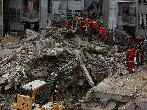 Pakistani troops, rescue workers and volunteers look for survivors amid the rubble of a collapsed building in Karachi, Pakistan, Monday, June 8, 2020.
