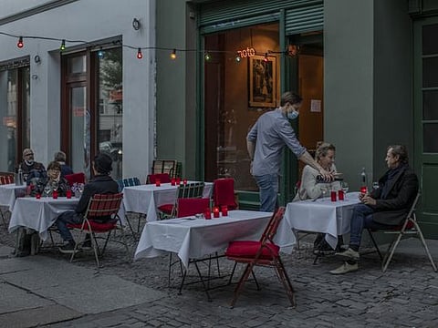 Patrons have dinner at ‘noto,’ a reopened restaurant in Berlin’s Mitte district, May 26, 2020. As Berlin emerges from its lockdown, residents are getting used to social distancing in bars and swimming pools — and to handing out their phone number several times a day to help in contact tracing.