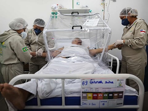 Health workers assist a COVID-19 patient at the Gilberto Novaes Municipal Hospital in Manaus, Brazil on June 8, 2020.