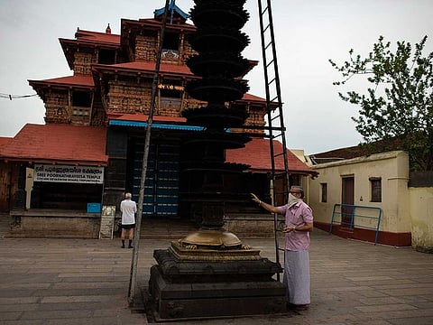 Devotees worship from outside a Hindu temple that remained closed to devotees due to the COVID-19 pandemic in Kochi, Kerala state, India, on Monday, June 8, 2020. 