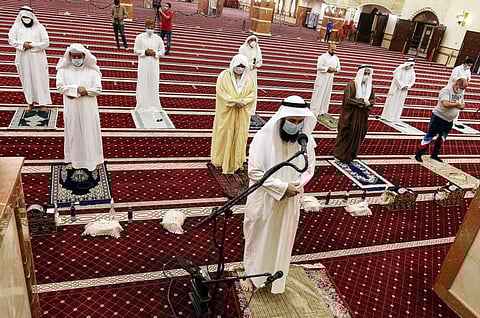 Muslim worshippers, distanced safely from each other and clad in face masks due to COVID-19, perform the noon prayers at a mosque in Kuwait City on June 10 for the first time since a lockdown was instated three months prior. 