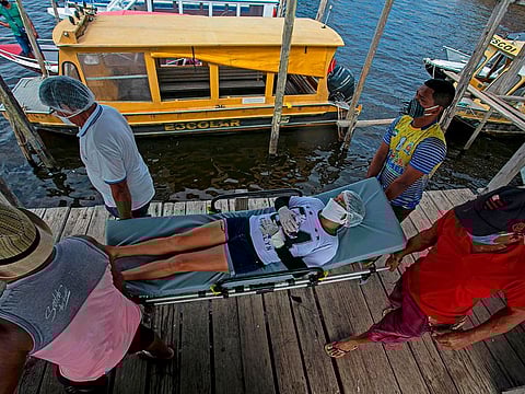 A patient with COVID-19 symptoms is transfered by ambulance boat to a hospital in Breves city, Para state, after being hospitalized for five days in Melgaco, southwest of Marajo Island, in Brazil on June 10, 2020. 