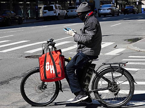 A Grubhub delivery person checks his phone in New York City.