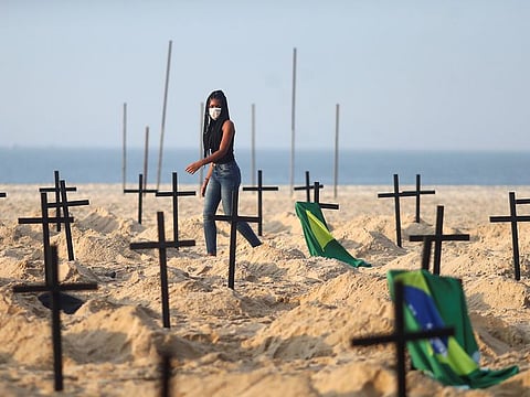 An activist of the NGO Rio de Paz wearing a protective mask attends a demonstration during which one hundred graves were dug on Copacabana beach symbolising the dead from the coronavirus disease (COVID-19), in Rio de Janeiro, Brazil, June 11, 2020. 