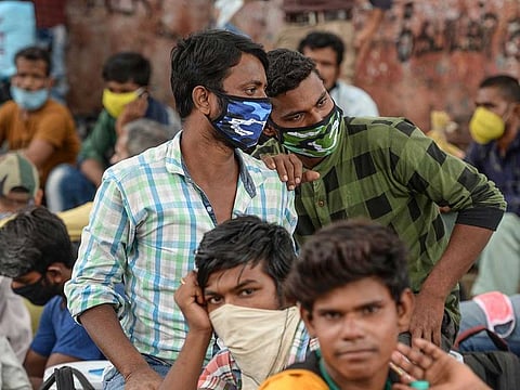 Migrant workers and families wait to get transferred to a railway station before boarding special trains to Bihar and Jharkhand states after the government eased a nationwide lockdown imposed as a preventive measure against the COVID-19 coronavirus, in Chennai on June 11, 2020. 
