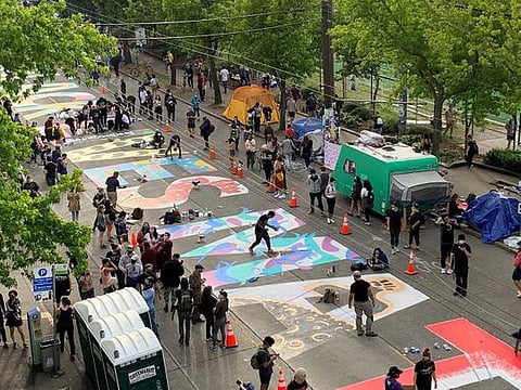 People create a Black Lives Matter mural on a street of Seattle, Washington, US