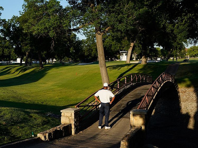 Harold Varner III examines his ball that landed on a bridge after his tee shot on the 10th hole during the second round of the Charles Schwab Challenge golf tournament at the Colonial Country Club in Fort Worth, Texas, Friday, June 12, 2020. (AP Photo/David J. Phillip)