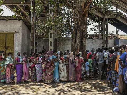 Migrant workers, many of whom are women, stuck in Mumbai, India, during the coronavirus lockdown line up for food in the sprawling slum of Dharavi on Monday, April 27. India’s women were already dropping out of the labour force.  