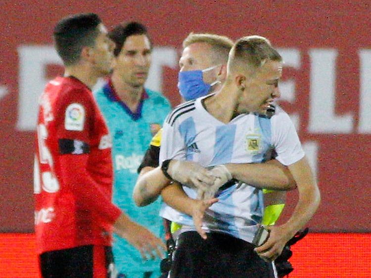 A supporter invades the pitch with Barcelona's Lionel Messi behind during the La Liga match between Mallorca and Barcelona.