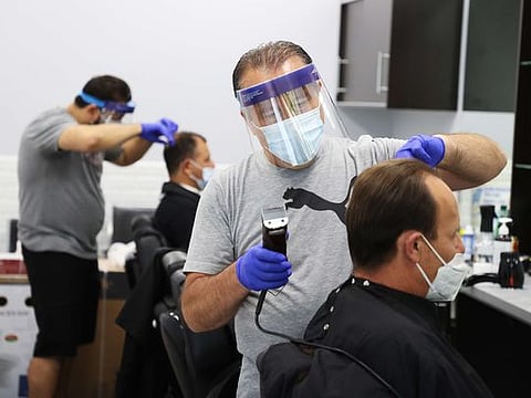 Yury Badalbayev cuts the hair of Paul Hayden at Barber Crew by Yury on June 10, 2020 in Bellmore, New York. Hair salons, barbershops, retail stores, car dealerships and restaurants on Long Island were permitted to open on June 10, 2020, as the region entered Phase II of New York State's plan to reopen the economy after closings were mandated due to the coronavirus pandemic. 