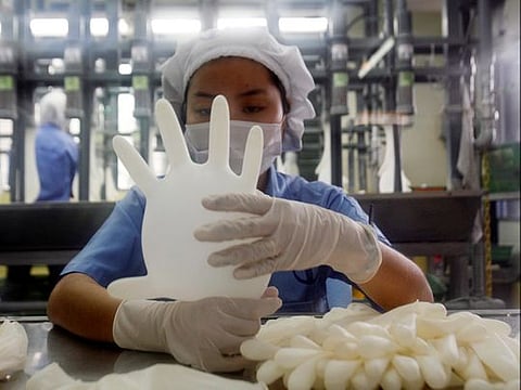 File photo: A worker carries out a test on a glove at a Top Glove factory in Meru outside Kuala Lumpur. 