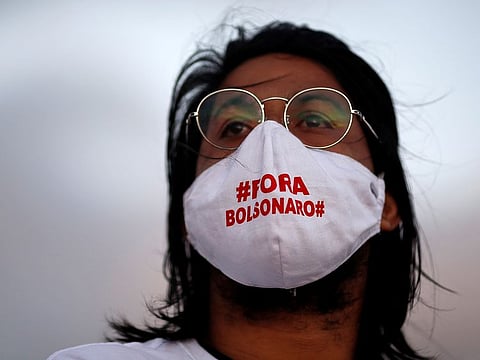 An artist wearing a protective mask reading "Out Bolsonaro" attends a protest to honour people who died from the coronavirus disease (COVID-19) during its outbreak in Brasilia, Brazil June 15, 2020. 