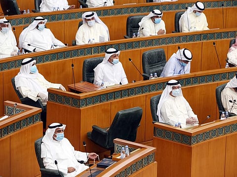 Kuwaiti MPs, wearing protective masks, attend a parliament session at the national assembly in Kuwait City, on June 16.