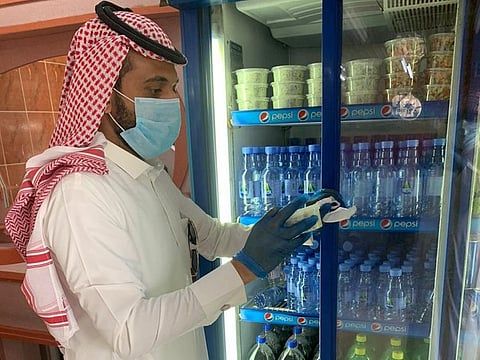 An inspector checks a salad container in a food store in the Saudi Governorate of Bareq. 